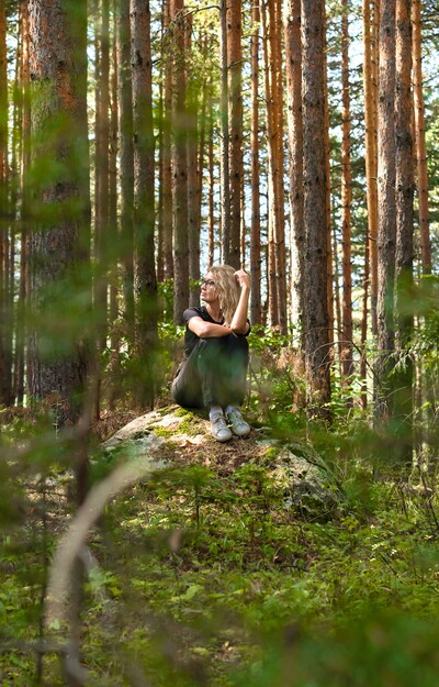 Frau sitzt am Felsen